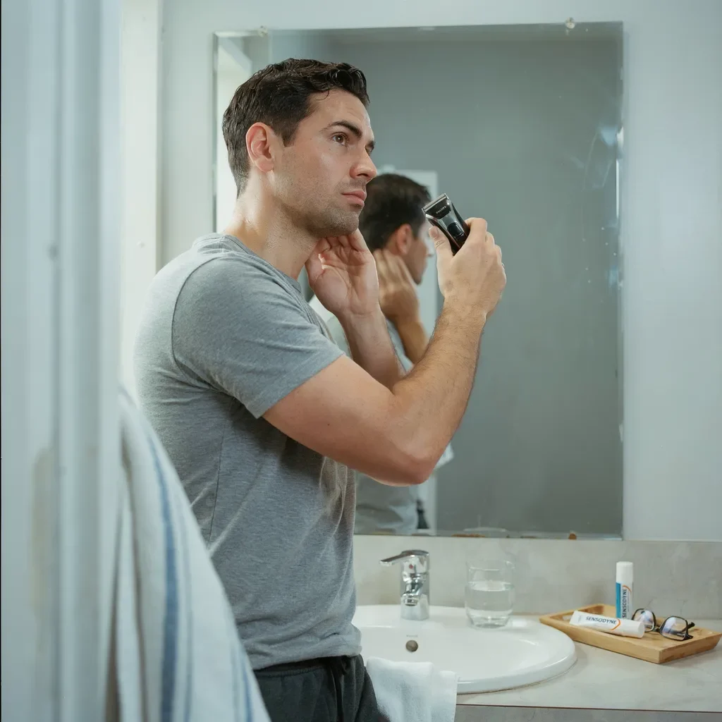 man trimming his own neckline at home between cuts