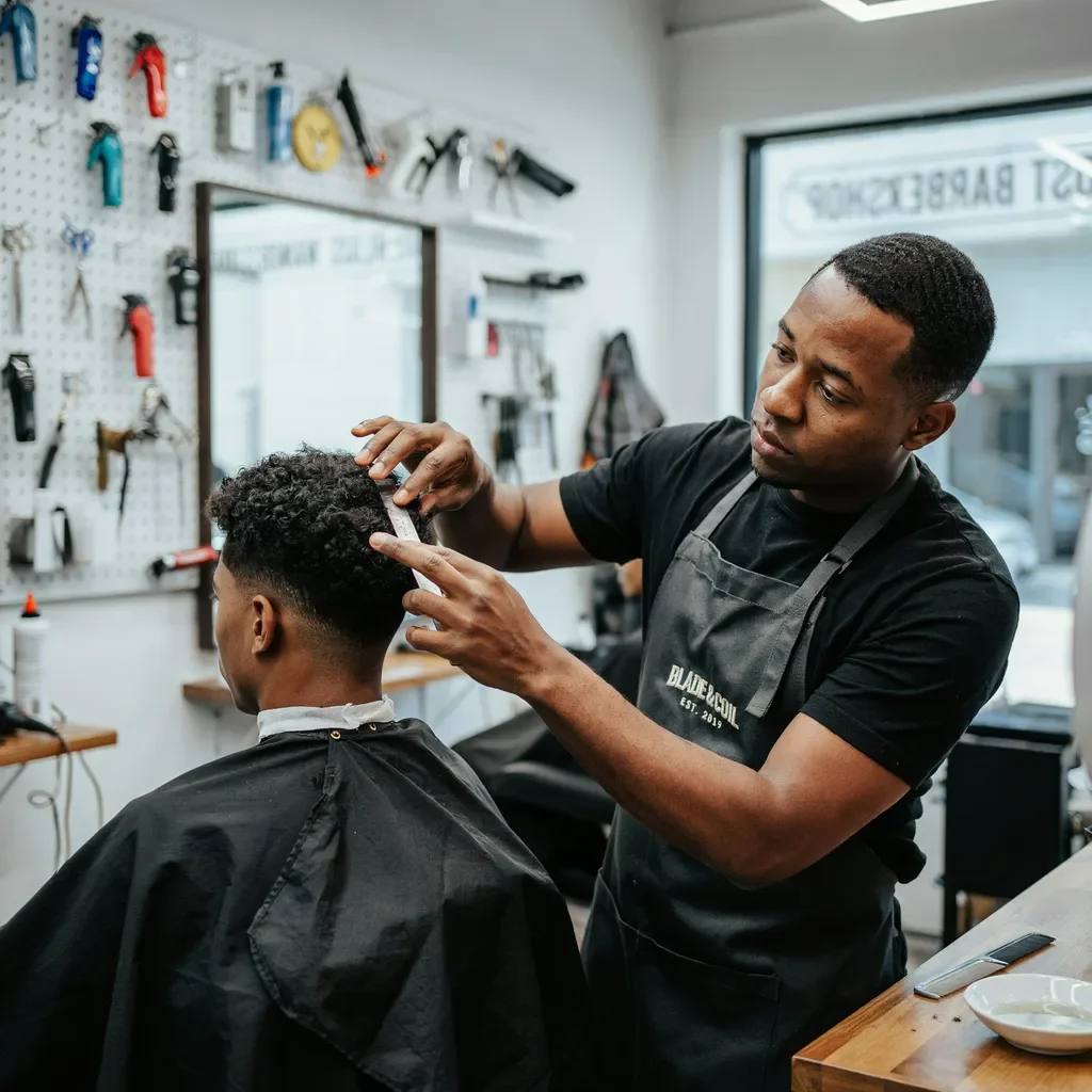 barber checking natural shrinkage of 4C hair