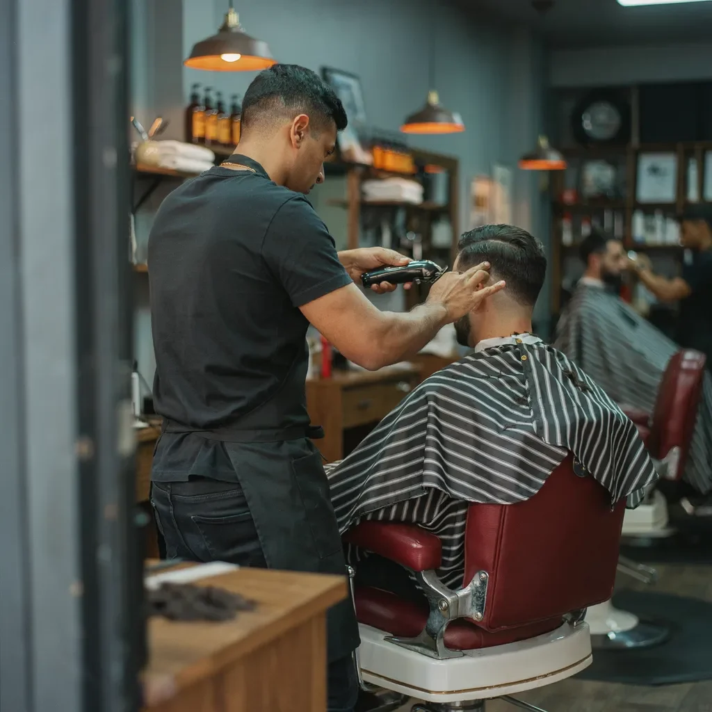 Barber finishing a lineup on a seated client