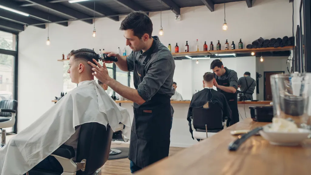Barber giving a client a mid fade in a busy barbershop