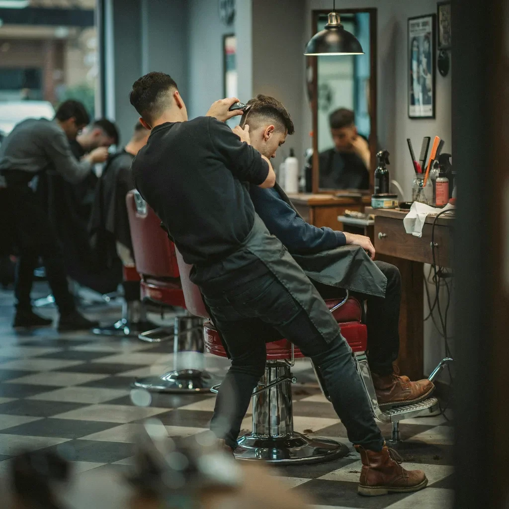 Barber inspecting a fresh fade on a seated client