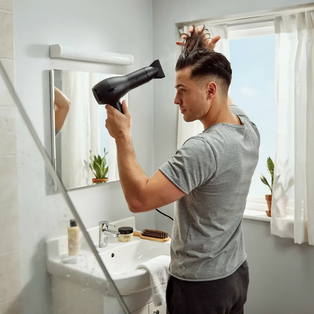 blow drying the top of a mid fade before styling