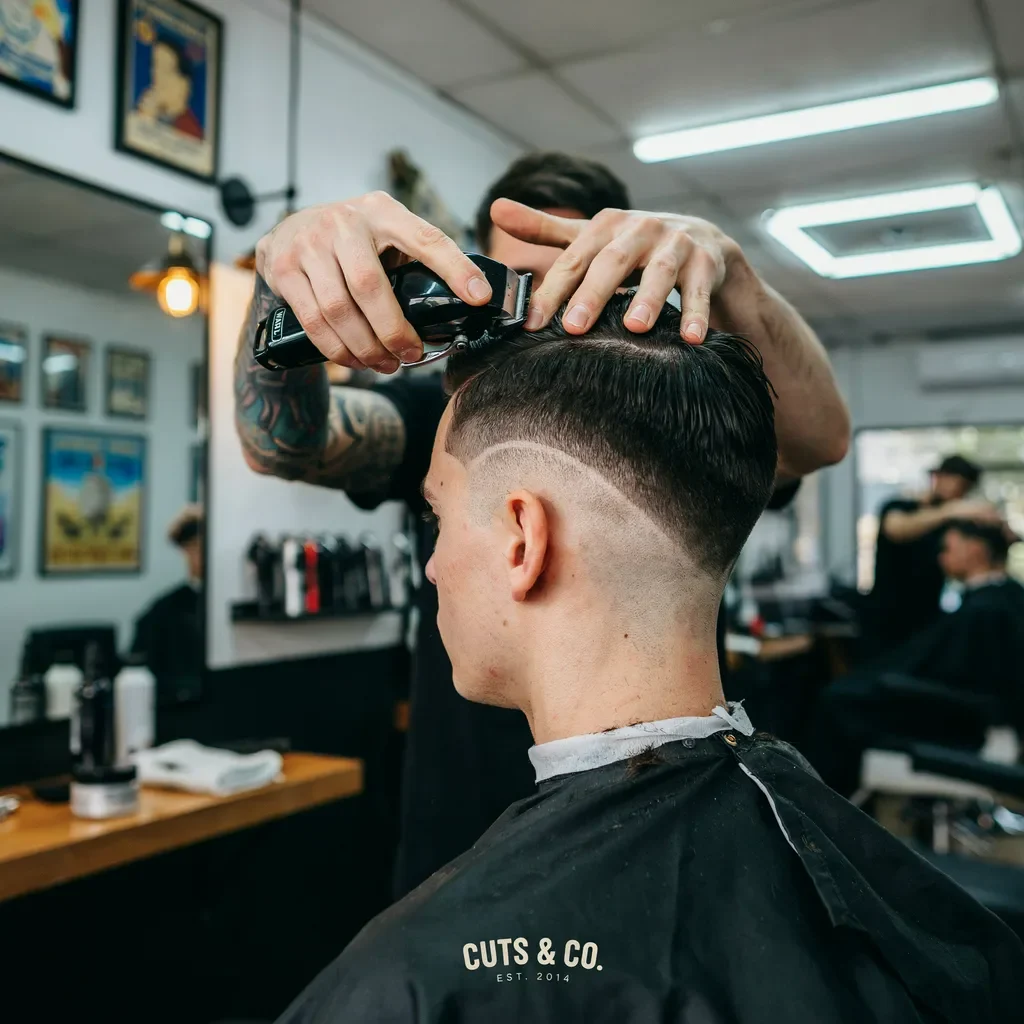 barber cutting a curved burst fade pattern
