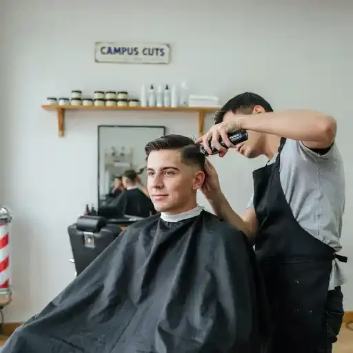 student getting a mid fade at a campus barbershop