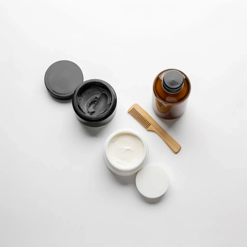 Flat lay of hair styling products: clay, pomade, and cream