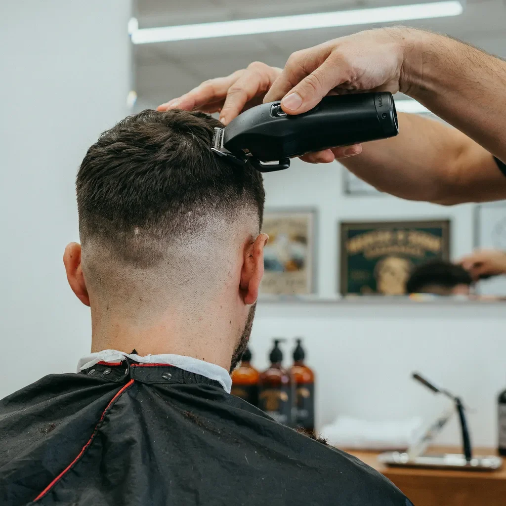 barber shaping a soft low taper neckline