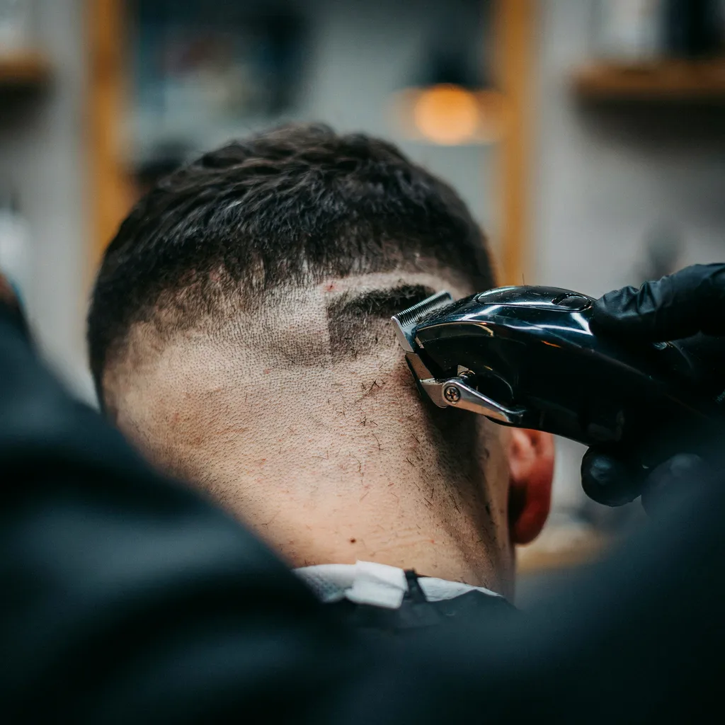 Clippers trimming a crisp neckline at the back of a mid fade