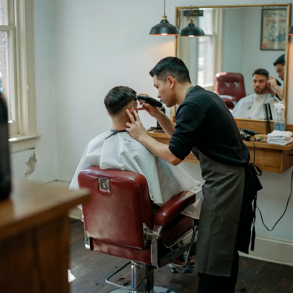Barber starting to fade the sides transitioning to a mid fade