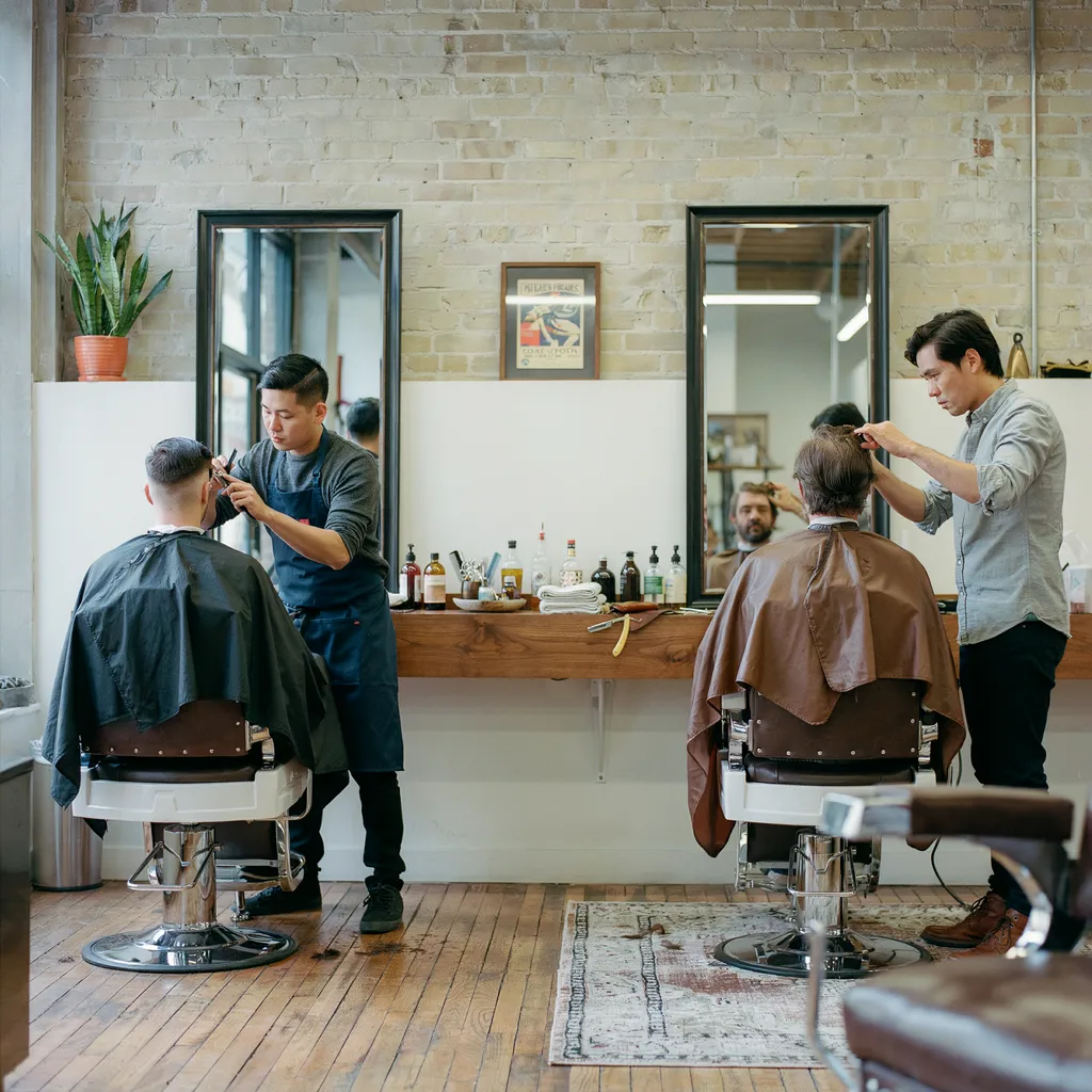 Two barbershop chairs showing different haircut styles being cut