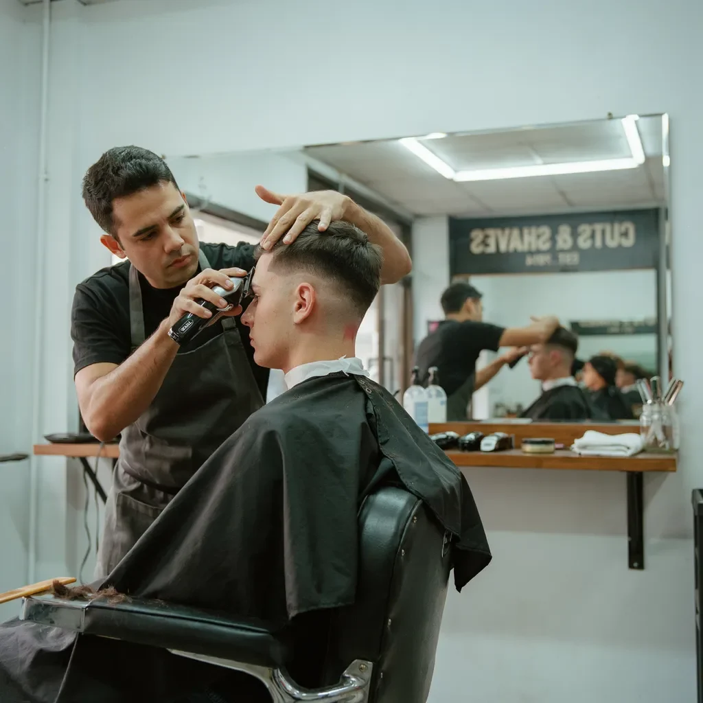 barber cutting a mid skin fade to bare skin
