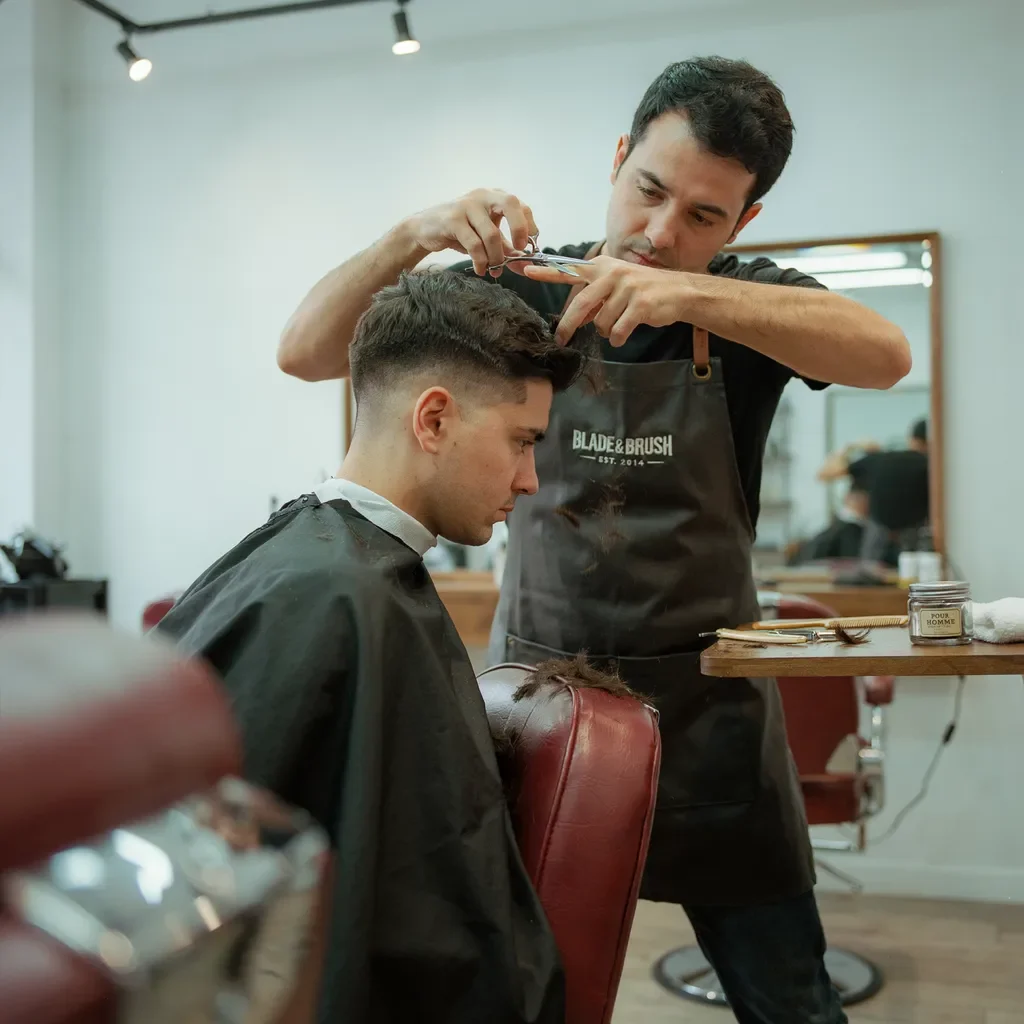 barber thinning a thick top for a taper fade